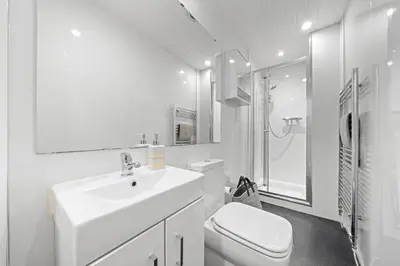 a white bathroom with a sink and a toilet at Couples or Golfers Near to Beach in Troon