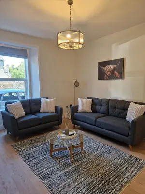 a living room with two couches and a coffee table at City Residence Free Parking in Stirling