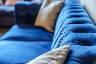 a close up of a blue couch with a pillow at Family and Group Stay 2BR by Park Sleeps 7 in Glasgow
