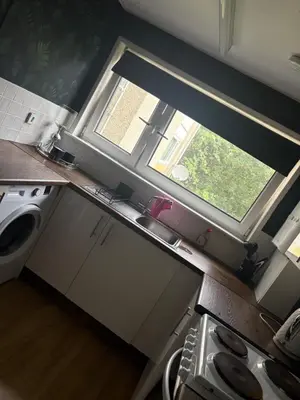 a small kitchen with a window and a sink at Modern 1 bedroom flat full flat in East Kilbride