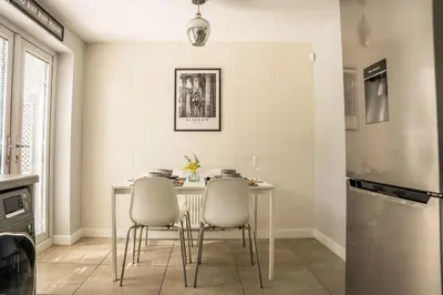 a kitchen with a table with chairs and a refrigerator at JustStay Glasgow - 3 Bedroom Luxury Villa with free parking in Bailleston