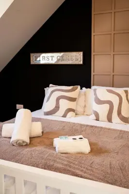 a bed with two white pillows and a sign on it at JustStay Glasgow - 3 Bedroom Luxury Villa with free parking in Bailleston