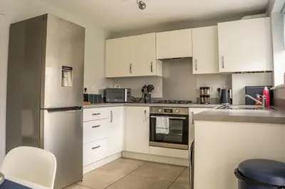 a kitchen with white cabinets and white appliances at JustStay Glasgow - 3 Bedroom Luxury Villa with free parking in Bailleston