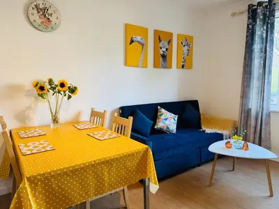 a living room with a table and a blue couch at Murrayfield Maindoor flat with Free parking and Great Public transports Link in Edinburgh