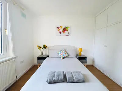 a bedroom with a white bed with two pillows on it at Murrayfield Maindoor flat with Free parking and Great Public transports Link in Edinburgh
