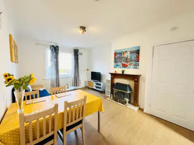 a living room with a dining table and a fireplace at Murrayfield Maindoor flat with Free parking and Great Public transports Link in Edinburgh
