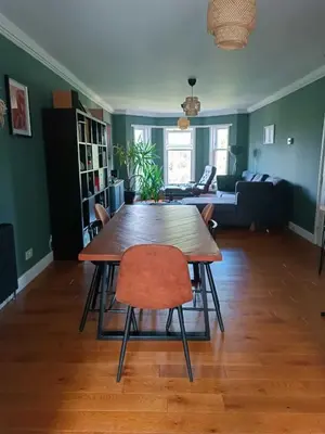 a living room with a wooden table and chairs at Modern Three-Bedroom Apartment in Leafy West End with Private Parking in Glasgow