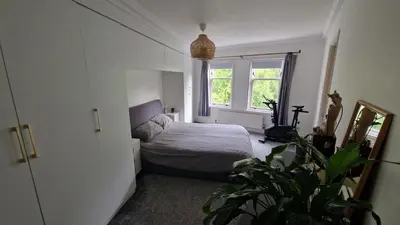 a bedroom with a bed and a window at Modern Three-Bedroom Apartment in Leafy West End with Private Parking in Glasgow