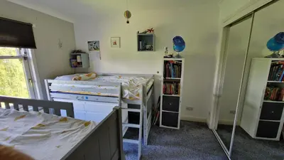 a bedroom with two beds and a book shelf at Modern Three-Bedroom Apartment in Leafy West End with Private Parking in Glasgow