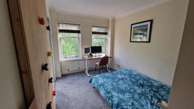 a bedroom with a bed and a desk with a computer at Modern Three-Bedroom Apartment in Leafy West End with Private Parking in Glasgow