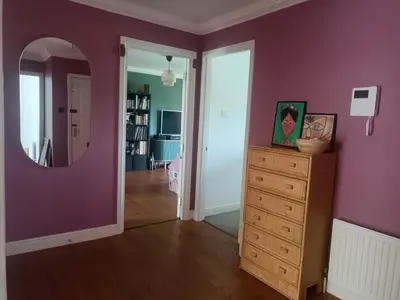 a room with a purple wall and a dresser and a mirror at Modern Three-Bedroom Apartment in Leafy West End with Private Parking in Glasgow