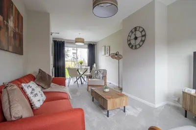 a living room with a red couch and a table at Gray House-Modern 2BR close to Loch Lomond in Alexandria