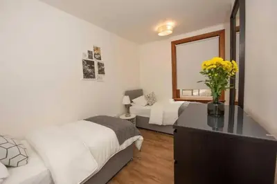 a bedroom with two beds and a desk with a mirror at Dalziel House-3 bedroom Hamilton in Hamilton