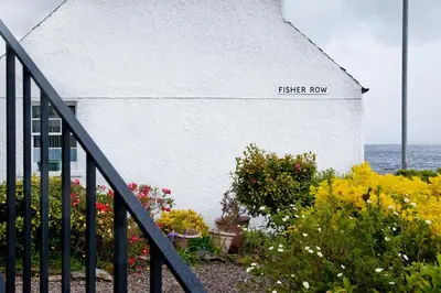 a white building with a sign that reads fischer row at Lochfyne-View Apartment in Inveraray