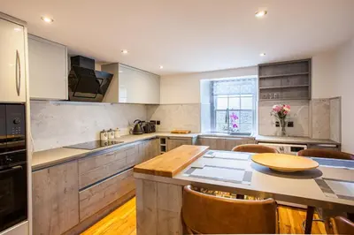 a kitchen with a table and some chairs in it at Lochfyne-View Apartment in Inveraray