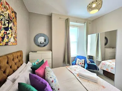 a bedroom with a bed with colorful pillows at Sensational Stay- Fountainbridge in Edinburgh