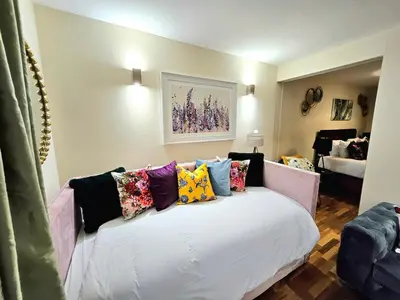 a room with a white couch with colorful pillows on it at 2 bedroom, 4 beds -Grassmarket in Edinburgh