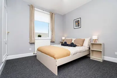 a white bedroom with a bed and a window at Ideal Work Stays 3BR Free Parking Sleeps 6 in Falkirk