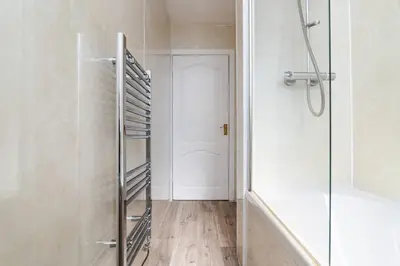 a bathroom with a shower and a glass door at Ideal Work Stays 3BR Free Parking Sleeps 6 in Falkirk