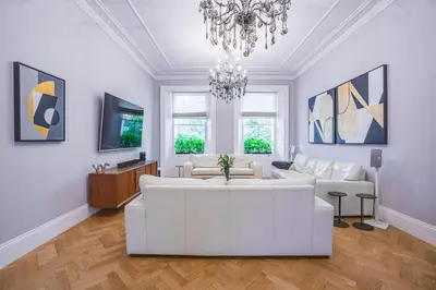 a living room with a white couch and a chandelier at The Victorian Residence in Moffat