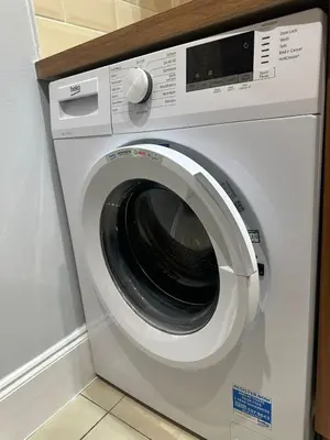 a washing machine is sitting in a room at City Centre Ground floor 3 Bedroom Apartment in Edinburgh