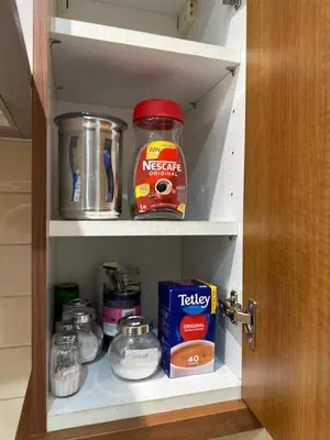 a cabinet with some food items in it at City Centre Ground floor 3 Bedroom Apartment in Edinburgh