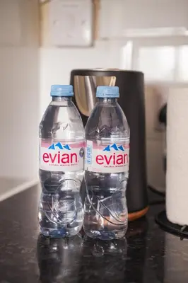 two bottles of water sitting on top of a counter at Coat Apartment in Coatbridge