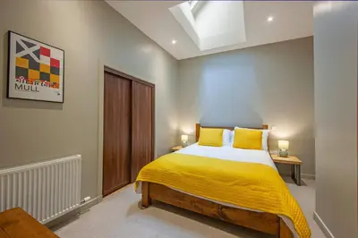 a bedroom with a bed with a yellow blanket at Stylish 2Bedroom Flat - Central Oban in Oban