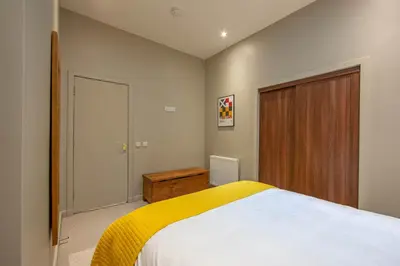 a bedroom with a bed and a wooden door at Stylish 2Bedroom Flat - Central Oban in Oban