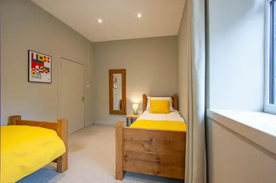 a bedroom with two beds and a window at Stylish 2Bedroom Flat - Central Oban in Oban