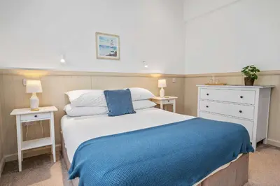 a bedroom with a bed with a blue blanket at Elegant 3BD Escape - Perfect Central Location in Oban