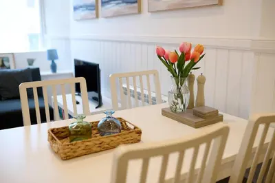 a table with a vase of flowers and a basket of books at Elegant 3BD Escape - Perfect Central Location in Oban