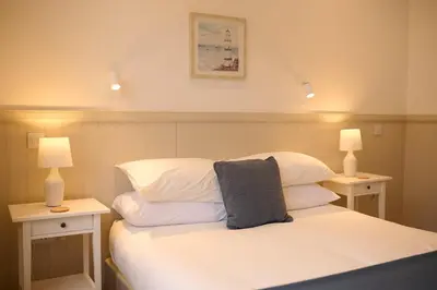 a bedroom with a bed with white sheets and two lamps at Elegant 3BD Escape - Perfect Central Location in Oban
