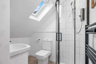 a white bathroom with a toilet and a sink at Breathtaking Sea Views - Luxury 2 BD Apt in Oban