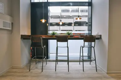 a kitchen with a bar with three stools at For Students Only - George Street in Glasgow in Glasgow