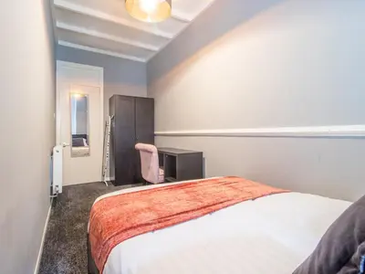 a bedroom with a bed and a chair in it at Pass the Keys Cosy in Fabulous West End in Glasgow