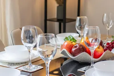 a table with wine glasses and a bowl of fruit at Cairnhill House - cosy 3 bedroom in Airdrie