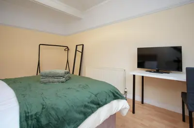 a bedroom with a bed and a flat screen tv at Group Stay 3BR Close to Hydro and SECC with Parking in Govan