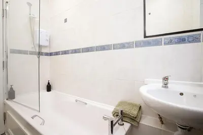 a bathroom with a tub and a sink and a bath tub at Group Stay 3BR Close to Hydro and SECC with Parking in Govan