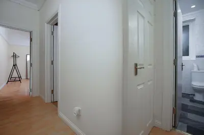 a hallway with a bathroom with a toilet and a door at Group Stay 3BR Close to Hydro and SECC with Parking in Govan