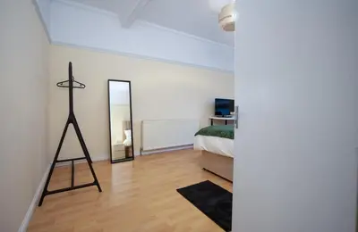 a bedroom with a bed and a mirror on the wall at Group Stay 3BR Close to Hydro and SECC with Parking in Govan