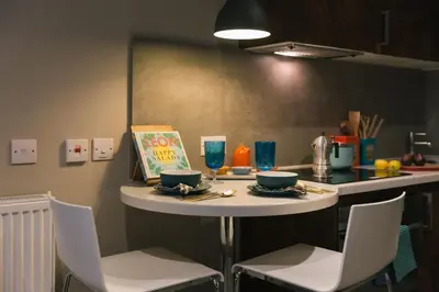 a small table in a kitchen with a book on it at For Students Only - Bath Street in Glasgow in Glasgow