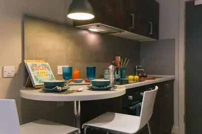 a small kitchen with a table and chairs in a room at For Students Only - Bath Street in Glasgow in Glasgow