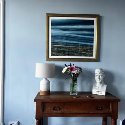 a table with a vase of flowers and a lamp at The Art Apartment in Kirn