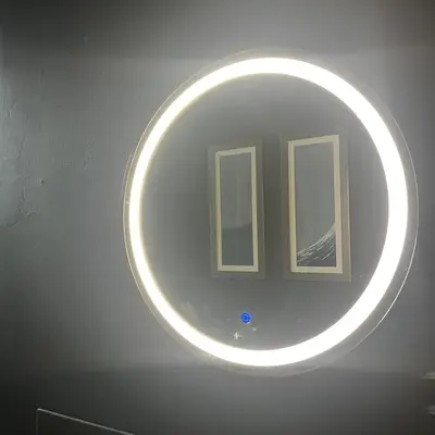 a round mirror on a wall with two windows at The Art Apartment in Kirn