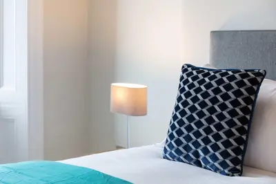 a bedroom with a bed with a pillow and a lamp at The Bay Suite - Donnini Apartments in Troon