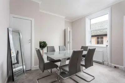 a dining room with a table and chairs and a mirror at The Bay Suite - Donnini Apartments in Troon
