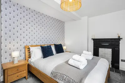 a bedroom with a bed with towels on it at The Old Jail - Iconic Views in North Queensferry