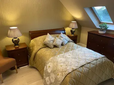 a bedroom with a bed with two night stands and two lamps at Doune Duck Ponds Accommodation in Doune