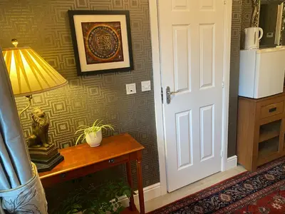 a room with a table with a lamp and a door at Doune Duck Ponds Accommodation in Doune